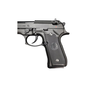 Close-up of the textured grip panel with embossed Beretta logo, safety lever and red loaded indicator dot